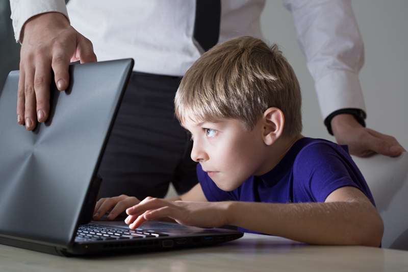 child on laptop as adult shuts it