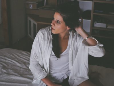 woman sitting on bed thinking