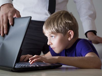 child on laptop as adult shuts it